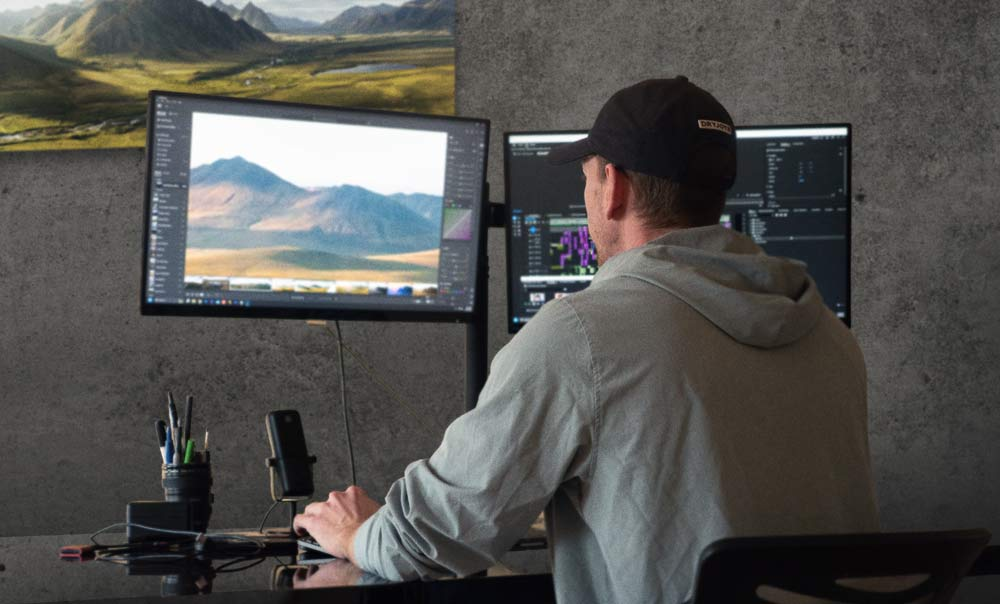 CoursePreview production workspace with dual monitors editing golf course imagery and video